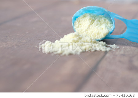 Close up of baby milk powder and spoon on tile background. 75430168