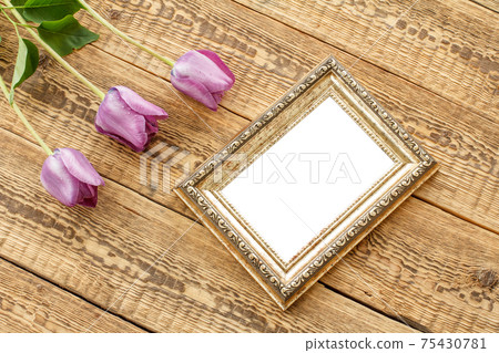 Vintage photo frame with tulips on wooden background. Vintage photo frame with tulips on wooden background. 75430781