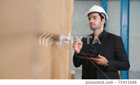 Factory manager using tablet computer in warehouse or factory Factory manager using tablet computer in warehouse or factory 75431606