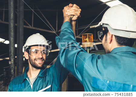 Two skillful factory engineer or worker showing teamwork and partnership . Two skillful factory engineer or worker showing teamwork and partnership . 75431885