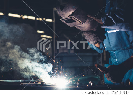 Skillful metal worker working with arc welding machine in factory Skillful metal worker working with arc welding machine in factory 75431914