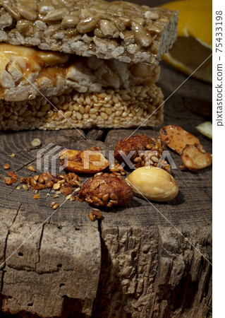 Kozinaki of sesame on the wooden background Kozinaki of sesame on the wooden background 75433198