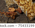 Kozinaki of sesame on the wooden background 75433199