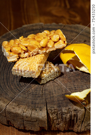 Kozinaki of sesame on the wooden background Kozinaki of sesame on the wooden background 75433250