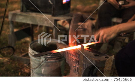 Blacksmith making hitting sword handmade traditional craftmanship show 75435666