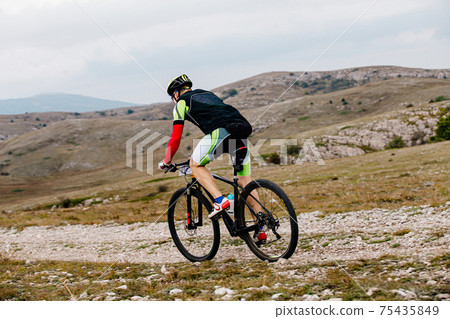 male cyclist biking on mountain trail male cyclist biking on mountain trail 75435849