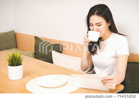Woman drinks coffee and relax at home. Woman drinks coffee and relax at home. 75435850