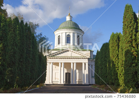 All Saints church in Nizhyn, Chernihivska oblast, Ukraine. Beautiful old building XVIII century with dome for religious purposes, Orthodox Church. Ukrainian baroque architecture. Shady alley. Scenery. 75436880