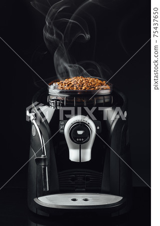 fresh roasted coffee beans with smoke in coffeemaker bean container, close-up view fresh roasted coffee beans with smoke in coffeemaker bean container, close-up view 75437650