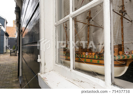 Close-up of the little marine white ship model from the wood on a windowsill in the Wooden Traditional House in Marken, Netherlands Close-up of the little marine white ship model from the wood on a windowsill in the Wooden Traditional House in Marken, Netherlands 75437738