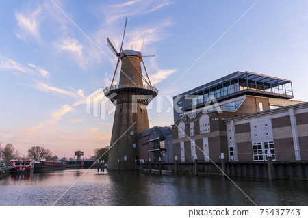 Twilight after sunset shot in Schiedam, Netherlands is famous for its windmills which are the highest in the world and also Jenever, a type of gin Twilight after sunset shot in Schiedam, Netherlands is famous for its windmills which are the highest in the world and also Jenever, a type of gin 75437743
