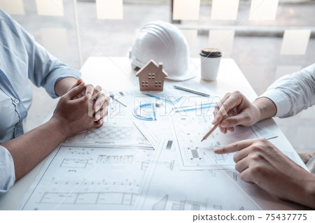 Architects or engineering team consulting and analyzing working on objects tools and construction drawings inspection planning new architectural project on blueprint and model house in modern office Architects or engineering team consulting and analyzing working on objects tools and construction drawings inspection planning new architectural project on blueprint and model house in modern office 75437775