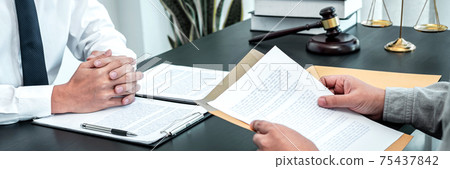 Male lawyer discussing negotiation legal case with client meeting with document contact in courtroom, law and justice concept Male lawyer discussing negotiation legal case with client meeting with document contact in courtroom, law and justice concept 75437842