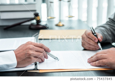 Male lawyer discussing negotiation legal case with client meeting with document contact in courtroom, law and justice concept 75437845