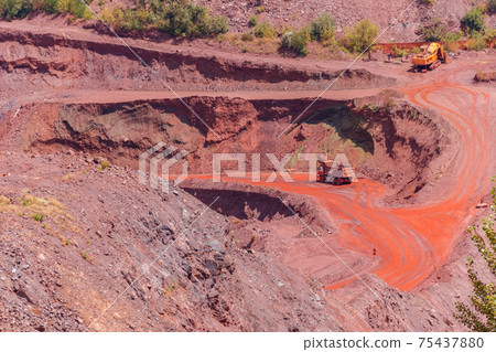 Huge iron ore quarry with working dump trucks and excavators in Kryvyi Rih, Ukraine 75437880