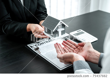 Sale Estate agent giving house model to new client after signing agreement contract with approved property form, Home Insurance and Real estate investment concept 75437882