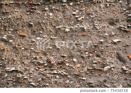 occupation earth - layers of ground with fragments of ancient pottery and shells under the sod layer 75438538