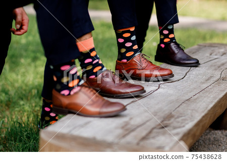 Fashion men footwear. guys wearing leather shoes and colorful socks on wooden bench. selective focus. Fashion men footwear. guys wearing leather shoes and colorful socks on wooden bench. selective focus. 75438628