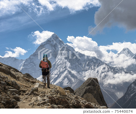 Hiker backdrop of majestic Himalayan mountains. Trekking to Everest. Nepal. Hiker backdrop of majestic Himalayan mountains. Trekking to Everest. Nepal. 75440074