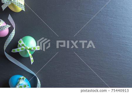 Easter set. Colorful egg with tape ribbon on dark rough stone background in Happy Easter decoration. Traditional design with copy space. 75440913