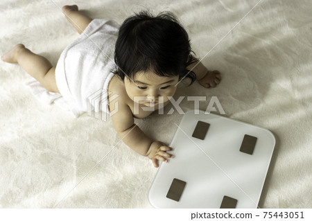 Image of weight measurement. Baby and scale (8 months old, girl) Image of weight measurement. Baby and scale (8 months old, girl) 75443051
