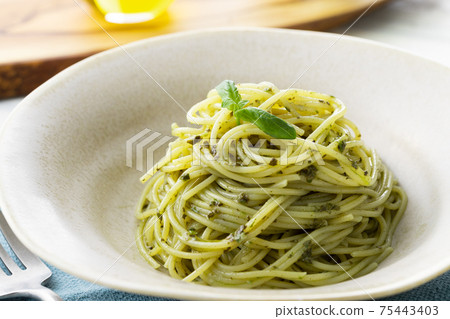 Spaghetti with basil sauce, shot on a natural background 75443403