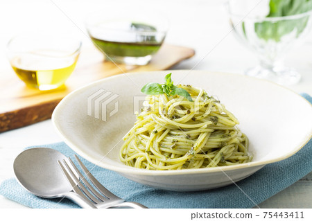 Spaghetti with basil sauce, shot on a natural background Spaghetti with basil sauce, shot on a natural background 75443411