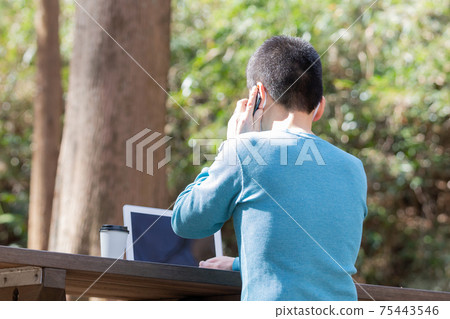 一個人在上半身外面的長椅上打電話的背影 75443546