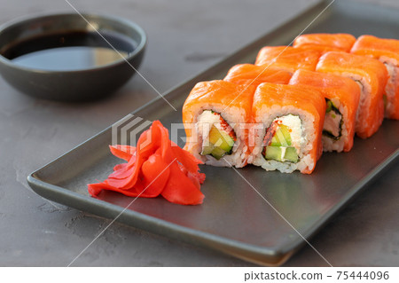 Philadelphia sushi roll served on black ceramic plate Philadelphia sushi roll served on black ceramic plate 75444096