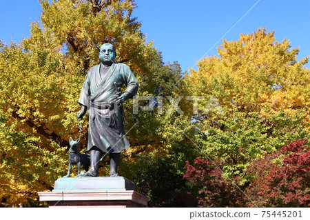 Saigo Takamori statue, a symbol of Ueno Park, standing with his dog against the backdrop of yellow leaves 75445201