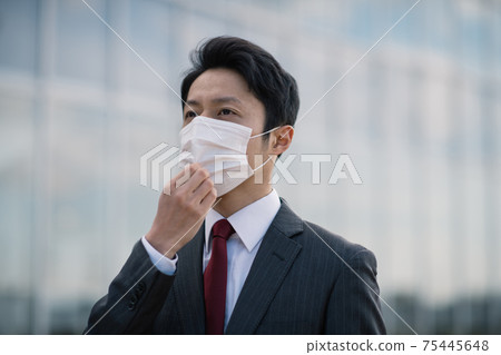 Japanese businessman in his thirties wearing a mask Japanese businessman in his thirties wearing a mask 75445648