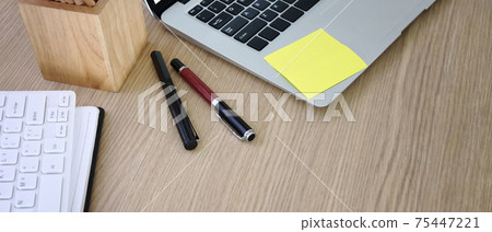 Horizontal photo of wooden office desk with laptop and stationery. Horizontal photo of wooden office desk with laptop and stationery. 75447221