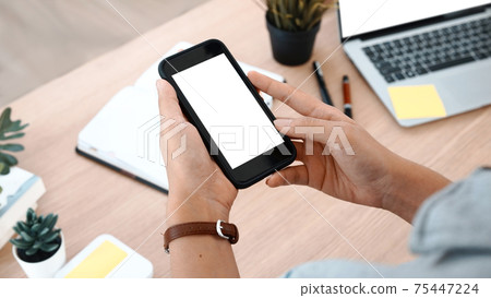 Close up view of young woman hands holding mobile phone. Blank screen for advertising text. Close up view of young woman hands holding mobile phone. Blank screen for advertising text. 75447224