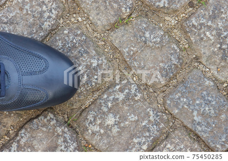 Comfortable navy blue leather shoes for men on road or footpath made of rocks or stones Comfortable navy blue leather shoes for men on road or footpath made of rocks or stones 75450285