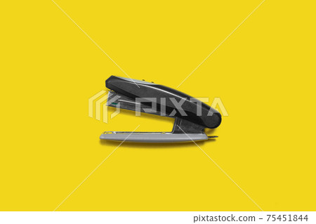 black metal and plastic stapler isolated on yellow back 75451844
