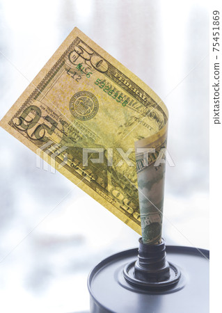 Barrel of oil on a background, american dollars background. Falling trend of barrel price decrease of earning and global economics . Selective focus. 75451869