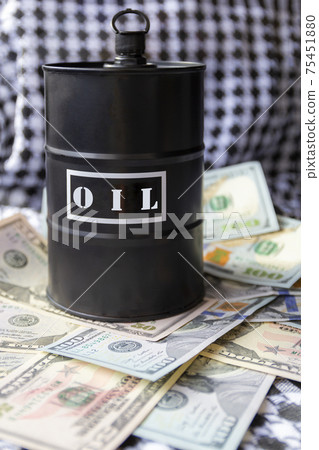 Barrel of oil on a background, american dollars and arabian background. Word on barrel is Oil. Falling trend of barrel price decrease of earning and global economics . Selective focus. 75451880