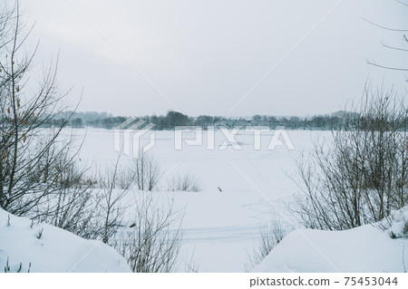 Winter frosty landscape of the river with broken ice 75453044