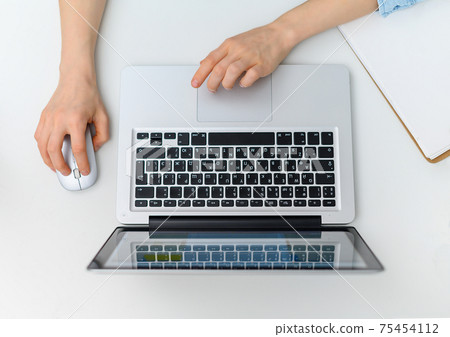 Workspace with hands typing on laptop. Flat lay, top view Workspace with hands typing on laptop. Flat lay, top view 75454112