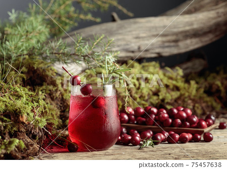 Cranberry cocktail with berries, ice, and rosemary in frozen glass. 75457638