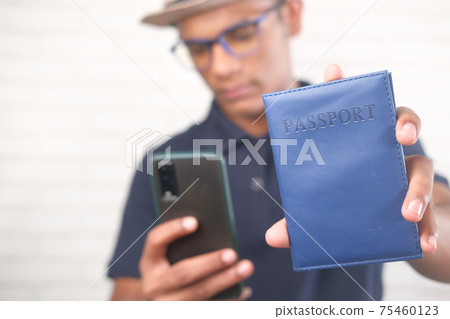 a traveler holding a passport and smart phone a traveler holding a passport and smart phone 75460123