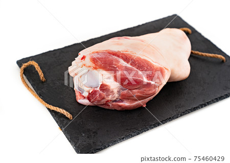 raw pork knuckle on black stone cutting board on white background. butcher shop. raw pork knuckle on black stone cutting board on white background. butcher shop. 75460429