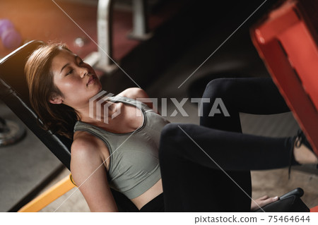 young sports woman doing fitness exercises for legs muscles in the gym young sports woman doing fitness exercises for legs muscles in the gym 75464644