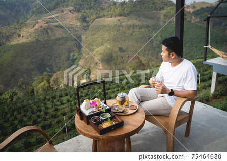 the man drinking hot green tea sitting on the chair mountain view 75464680