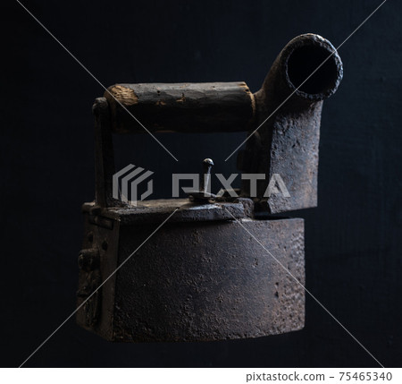 Old-fashioned rusty iron with wooden handle on black Old-fashioned rusty iron with wooden handle on black 75465340