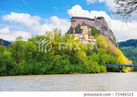 oravsky podzamok, slovakia - MAY 01, 2019: oravsky castle on the hill near the river. popular travel destination. beautiful springtime scenery in dappled light 75466525