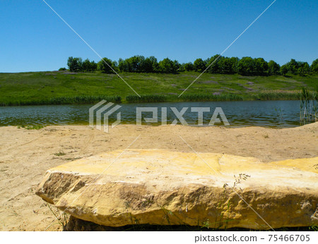 Lake beach with big flat stone. Countryside landscape with sunny sky. Lake beach with big flat stone. Countryside landscape with sunny sky. 75466705