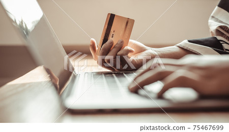 Woman's finger presses a keyboard and holds a credit card to register for payment or online transactions, Financial transactions and Internet security, Shopping online and banking online concept. Woman's finger presses a keyboard and holds a credit card to register for payment or online transactions, Financial transactions and Internet security, Shopping online and banking online concept. 75467699