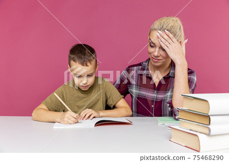 Mother helps her son to study at home. School closed because of quarantine. Mother helps her son to study at home. School closed because of quarantine. 75468290