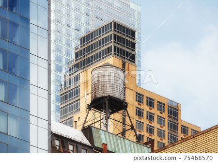 Water tower among modern buildings in Manhattan, New York City, USA. Water tower among modern buildings in Manhattan, New York City, USA. 75468570